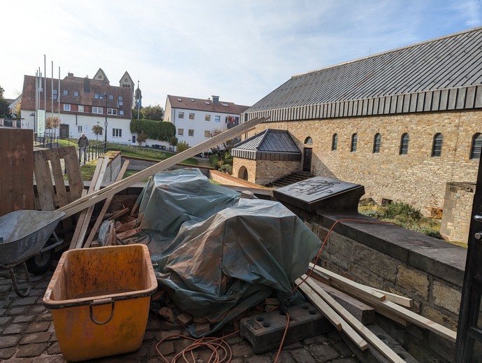 Schubkarren, Holzlatten und Planen vor den Gebäude des Museums in der Kaiserpfalz