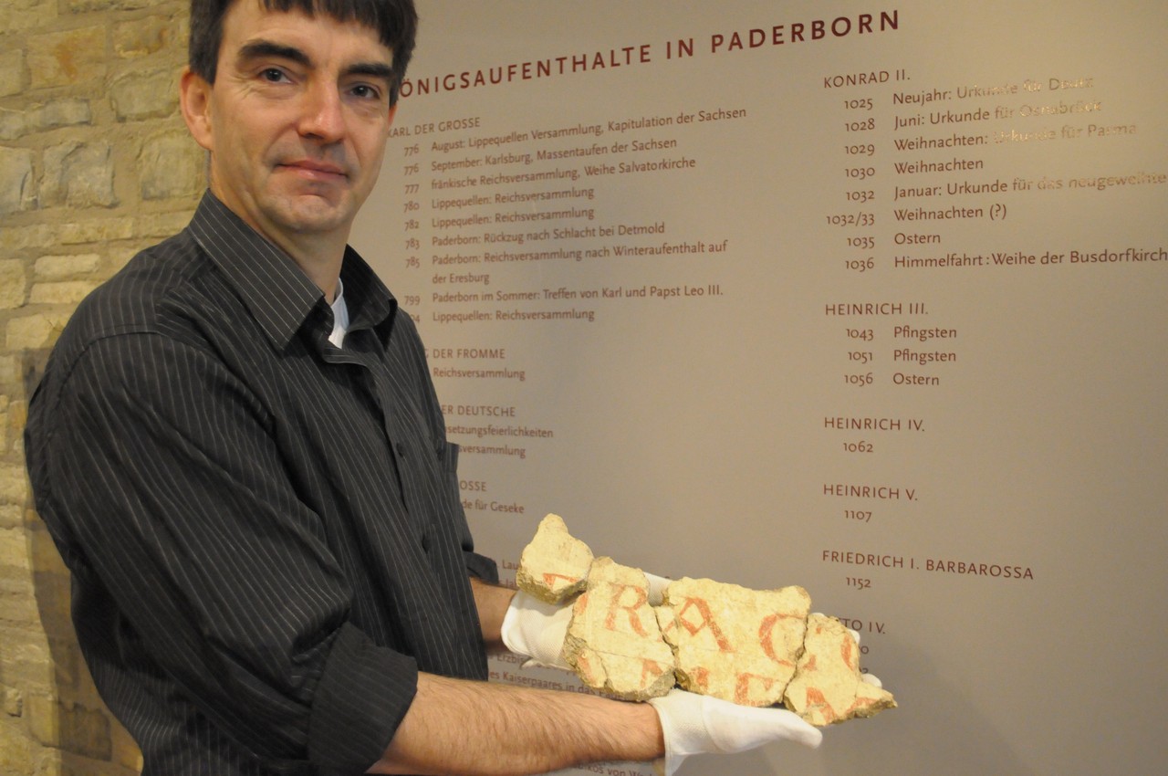 Der Restaurator Andreas Weisgerber präsentiert vorsichtig das Draco-Fragment. Foto_LWL_N.Zimmermann