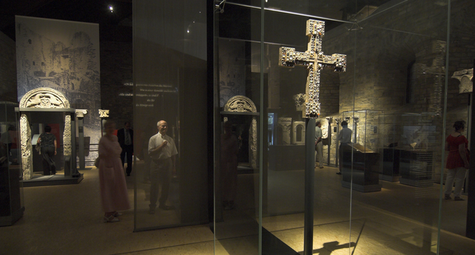 Blick in die Ausstellung "Canossa". Im Vordergrund ein mit Edelsteinen besetztes Vortragekreuz.